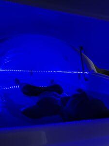 Man laying down inside of a salt pod during flotation therapy