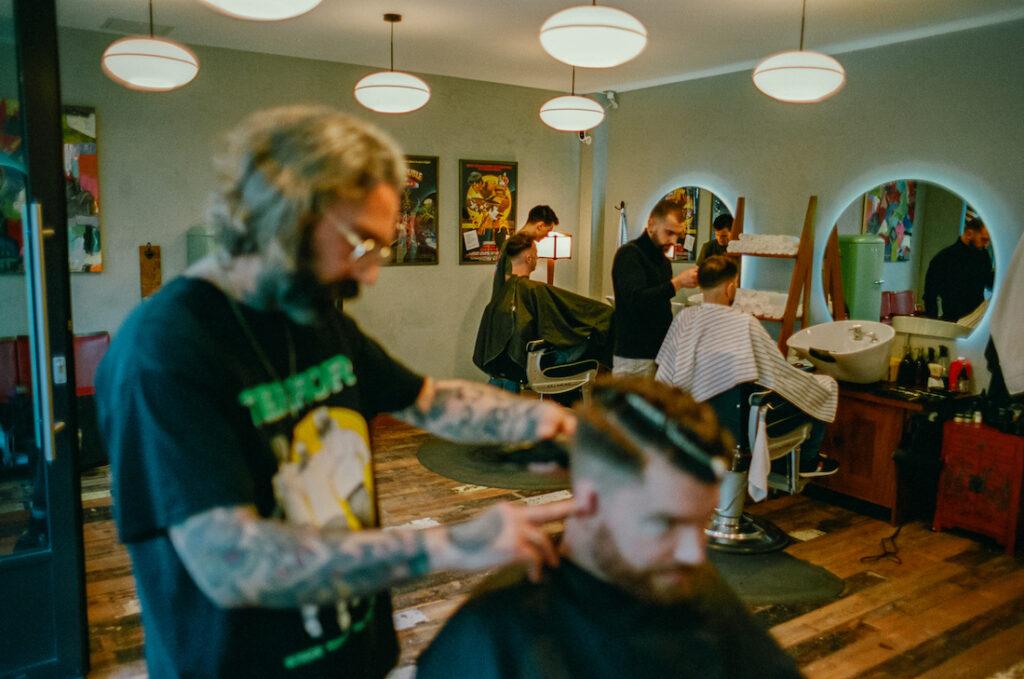 Barbers cutting hair at Dans Barbershop in South London