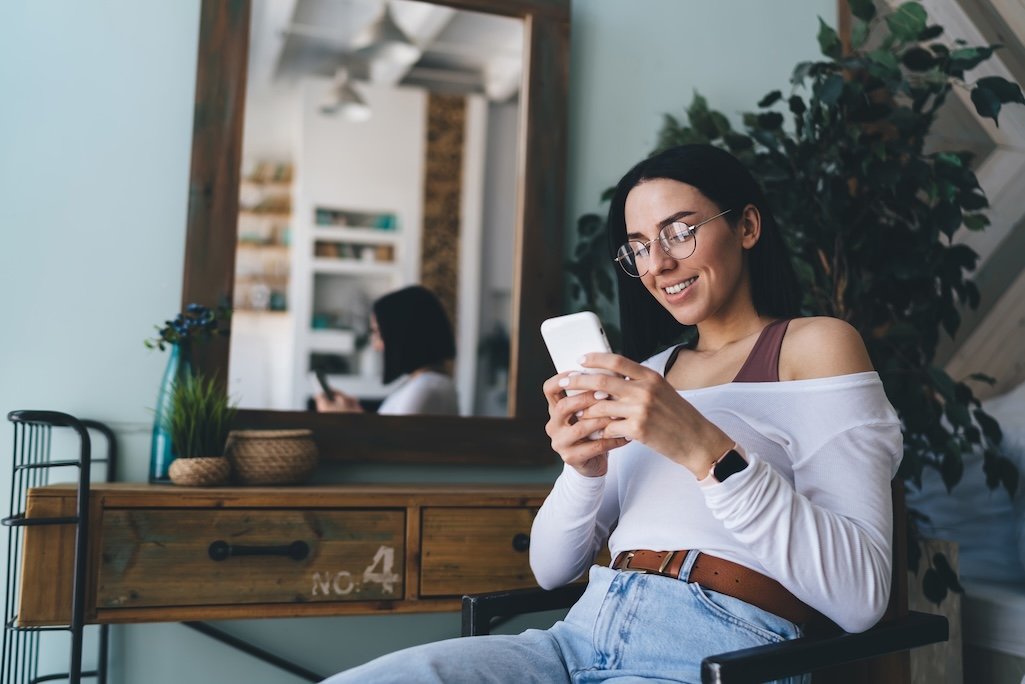 cheerful-woman-using-smartphone-at-home-2025-03-25-00-53-14-utc.jpg
