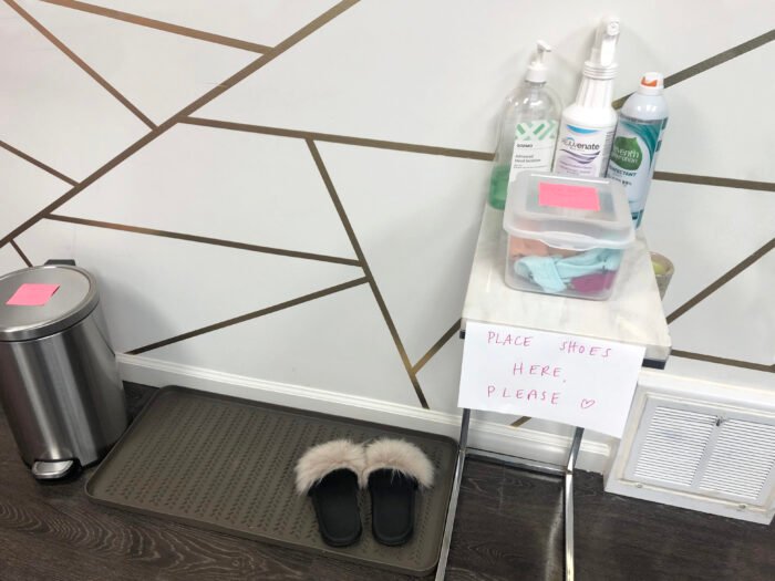 hand sanitizer station and shoes on a mat