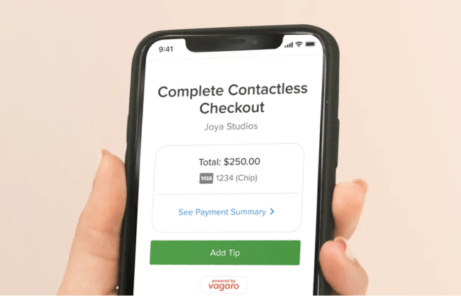 A person using Apple pay on Vagaro's salon POS card reader.